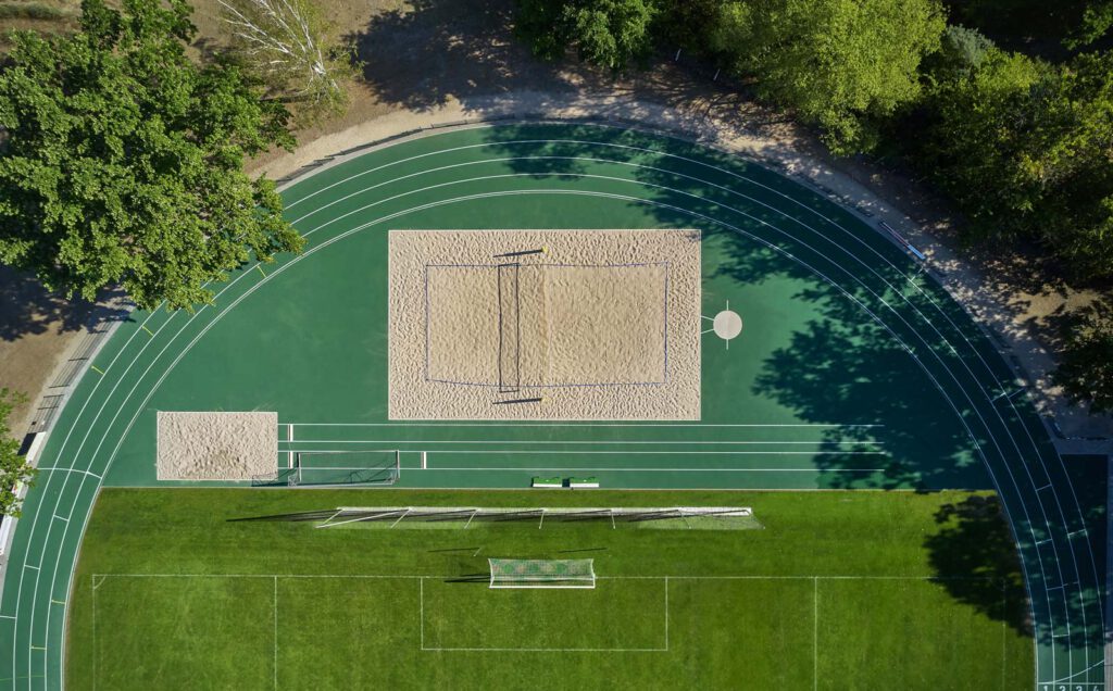 Luftbild der Laufbahn mit Beachvolleyball- und Fußballfeld auf der Sportanlage des SV 1908 Grün-Weiss Ahrensfelde-Anlage